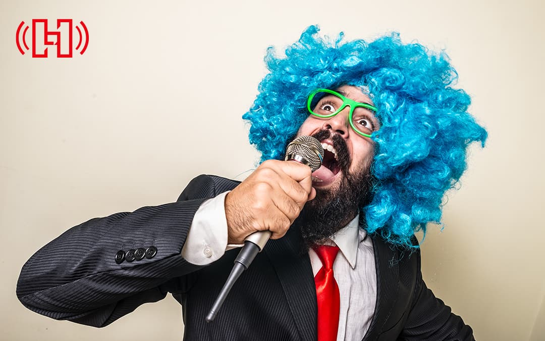 Bearded Man in a Suit With a Blue Wig Yelling into a Microphone